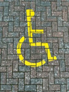 a handicapped sign painted on a brick sidewalk