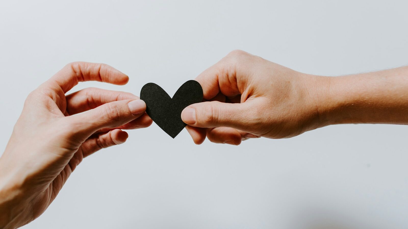 two person holding papercut heart