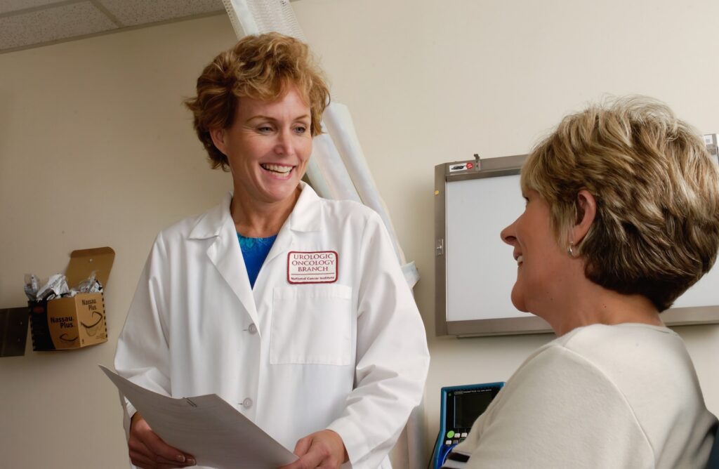 woman in white scrub suit holding gray laptop computer