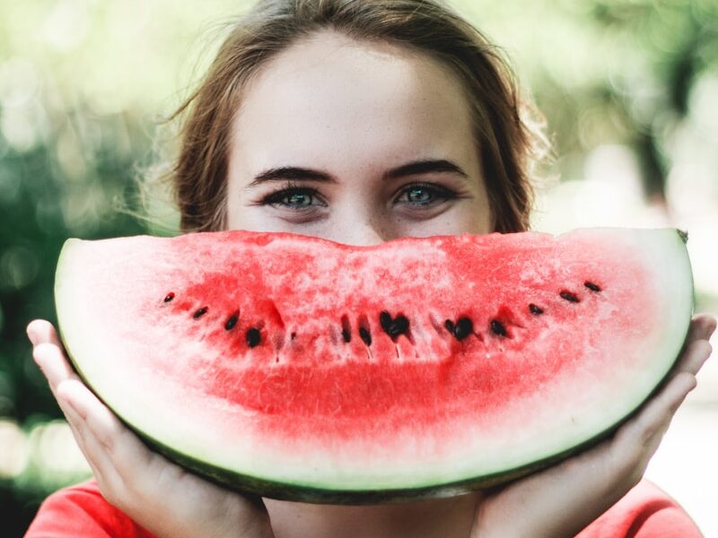 woman holding sliced watermelon