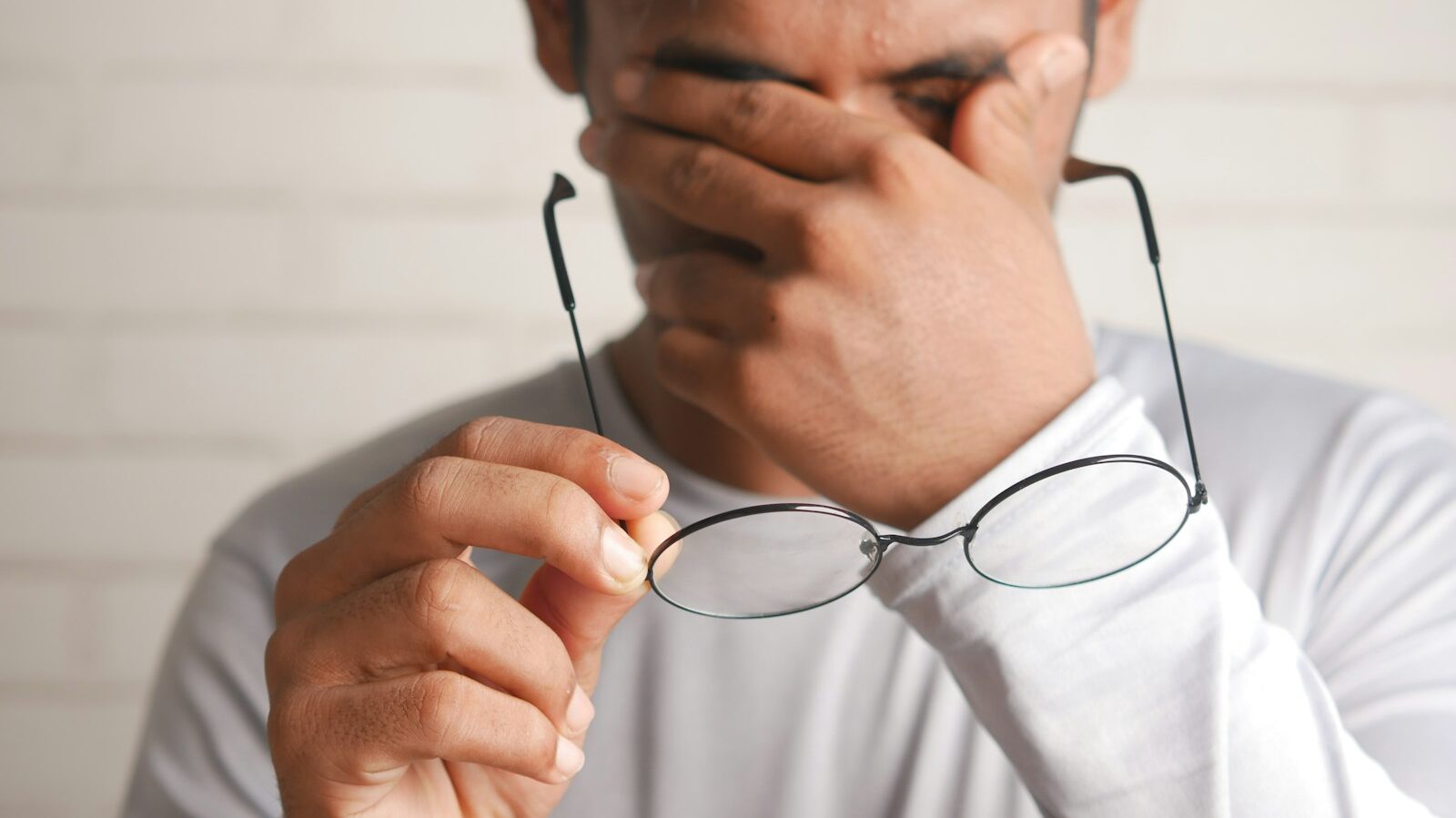 a man holding a pair of glasses up to his face