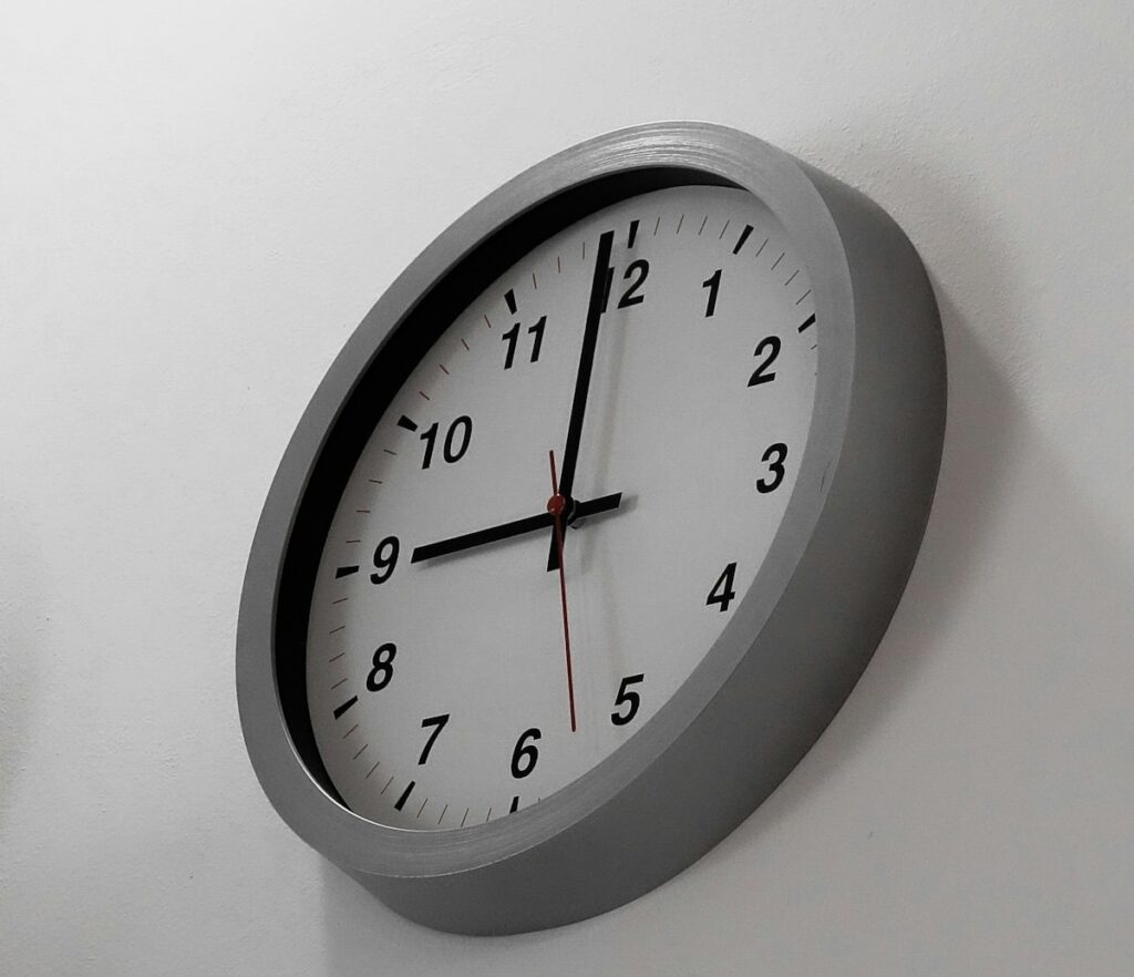 a clock mounted to the side of a white wall