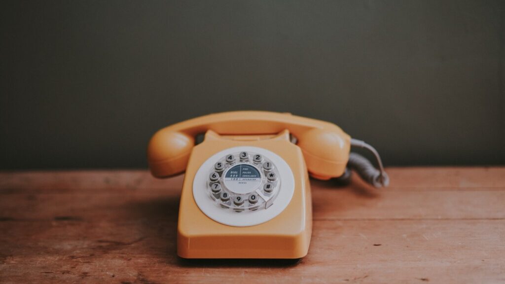 brown rotary dial telephone in gray painted room