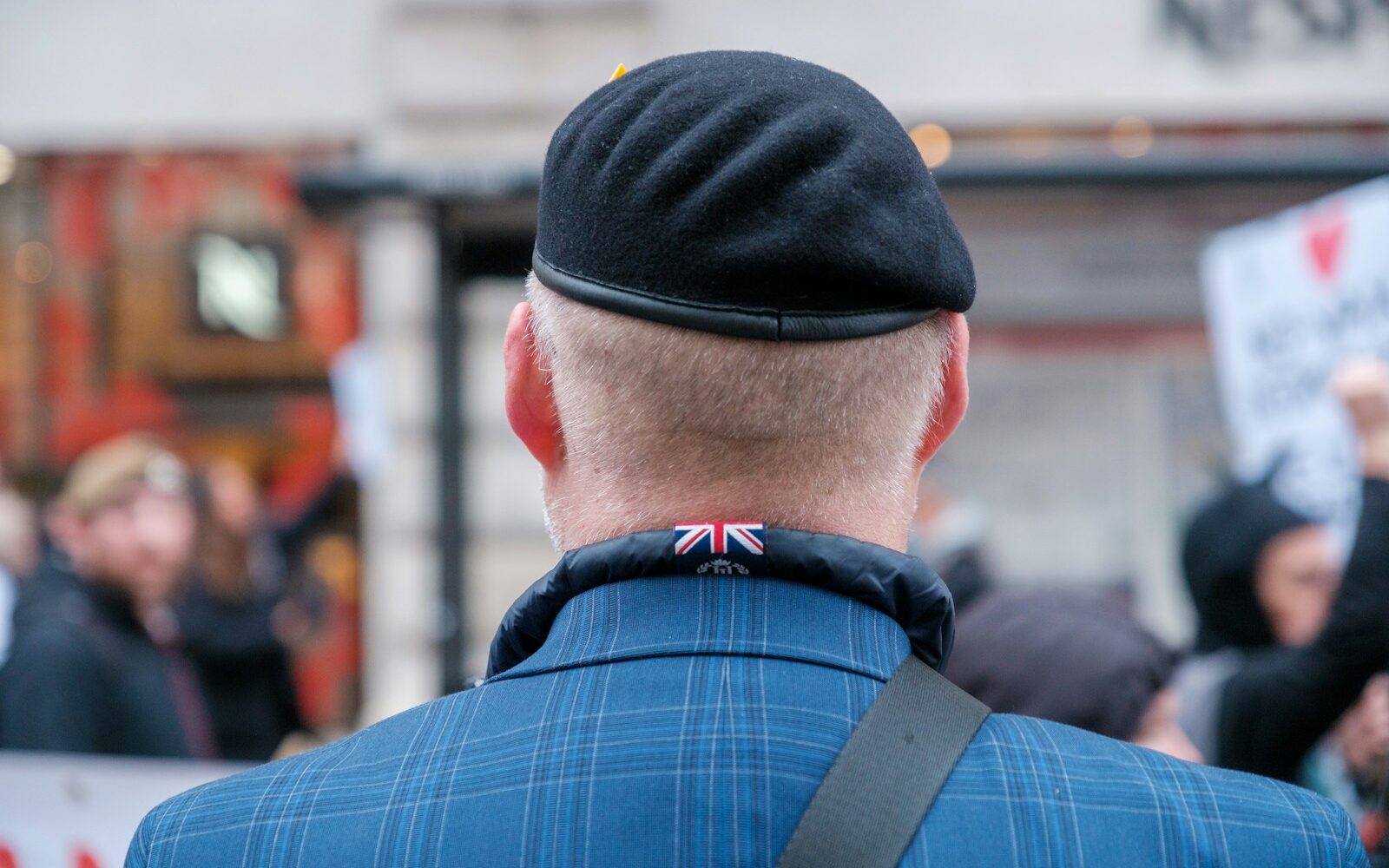 a man wearing a blue jacket and a black hat