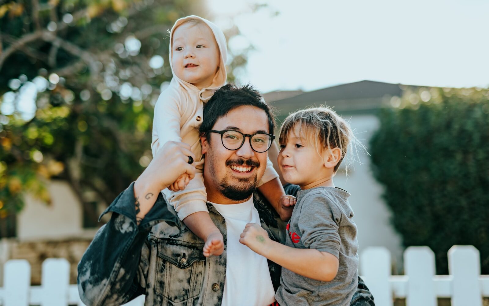 man in white shirt carrying girl in gray shirt