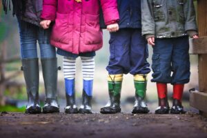 four children standing on dirt during daytime