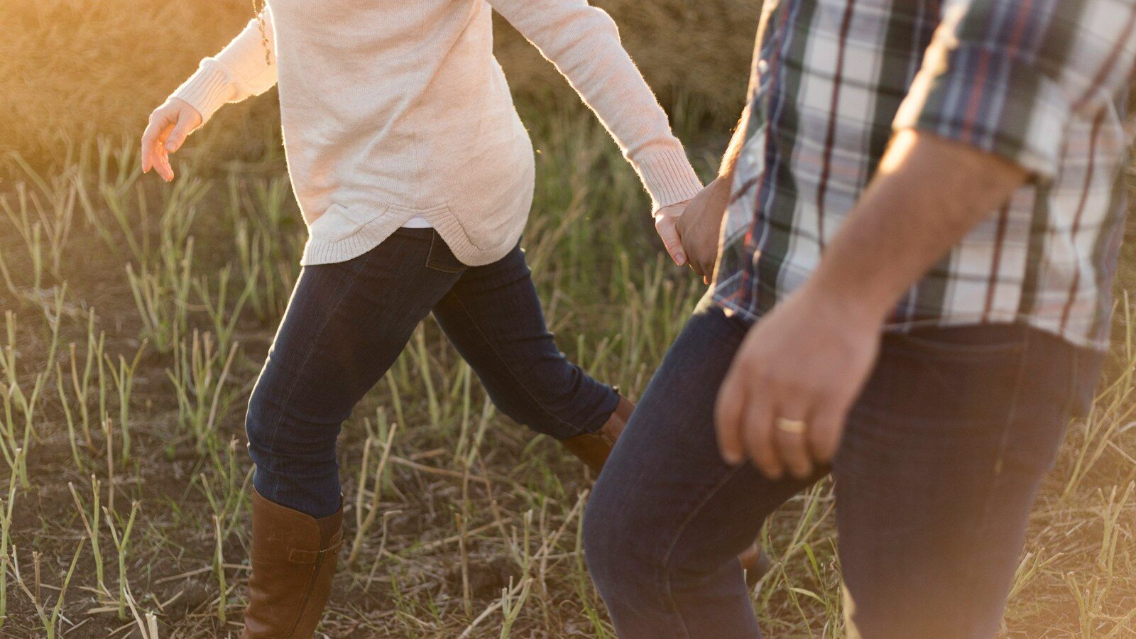 two person wearing denim pants on grass field