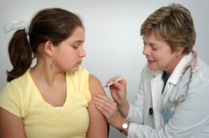 woman injecting girl's left arm