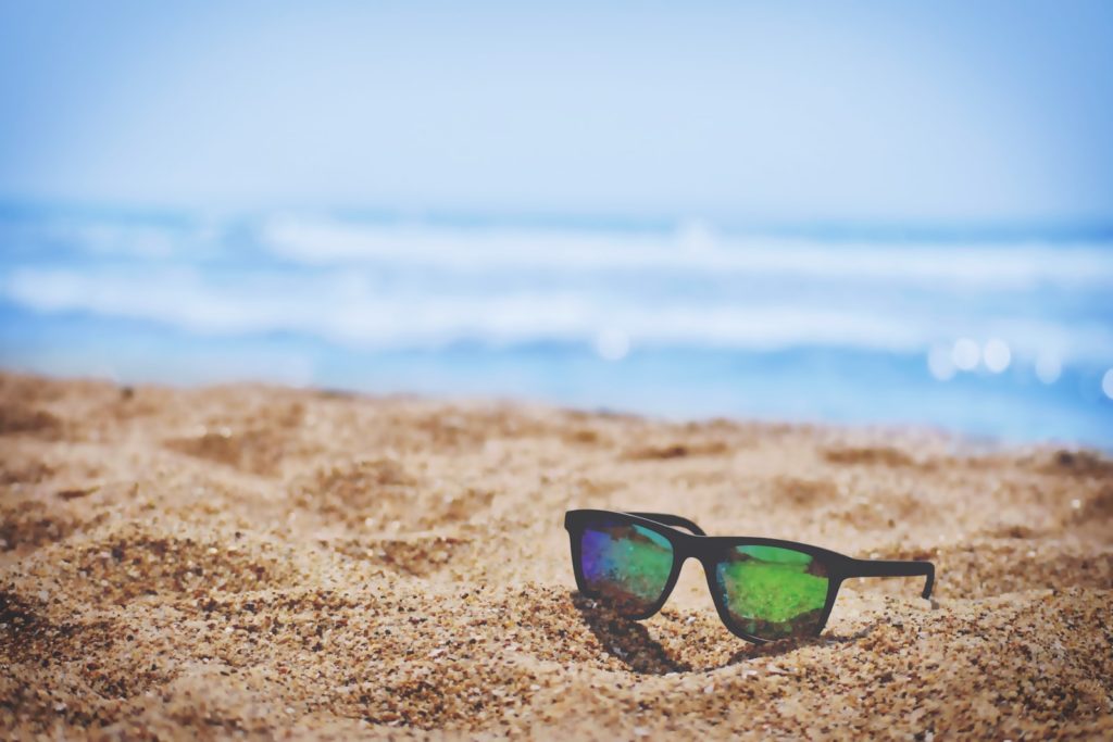 wayfarer sunglasses on beach sand during daytime