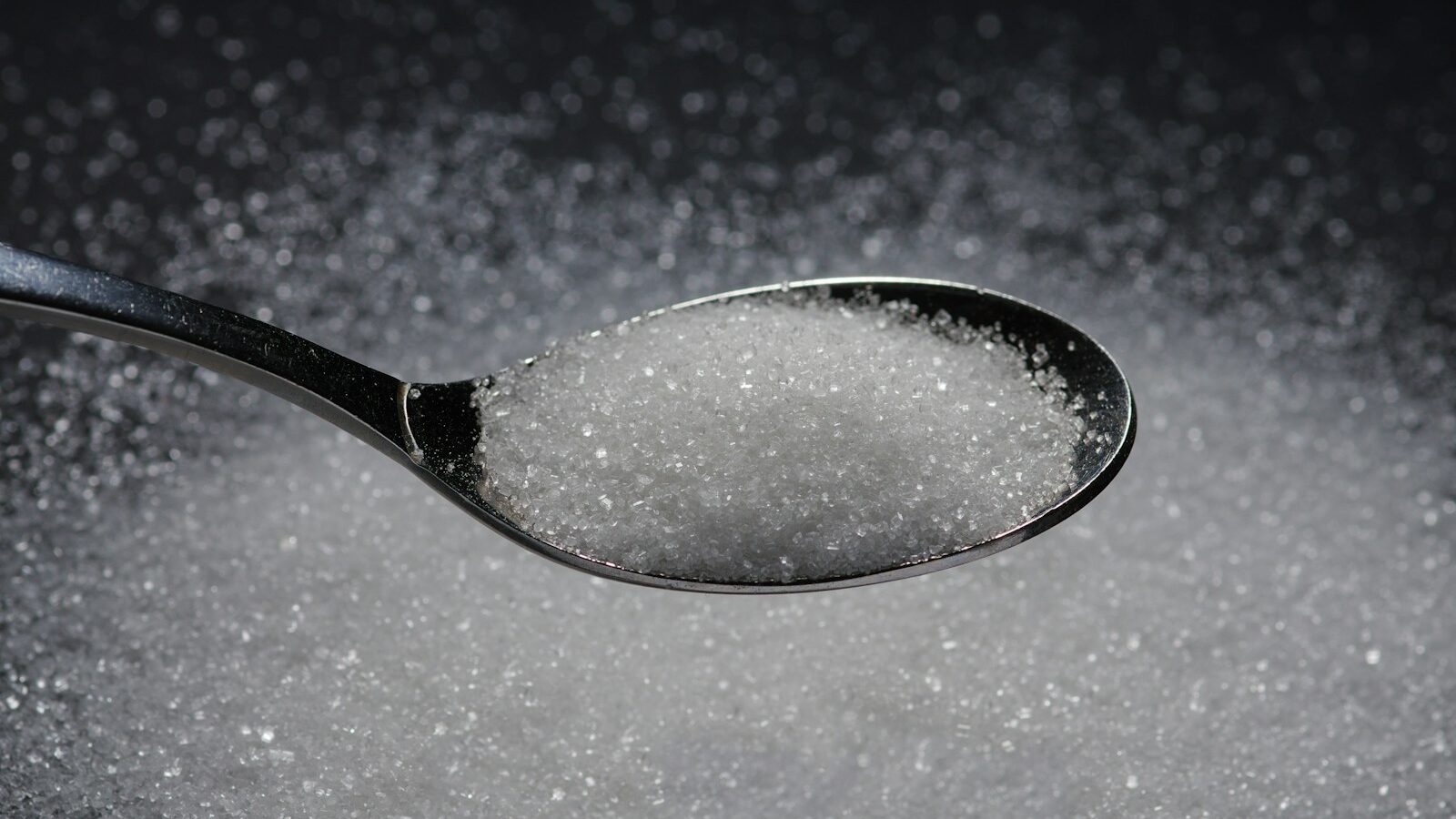 a spoon filled with sugar on top of a table