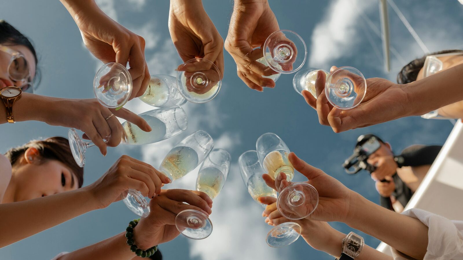 people holding clear glass bottles during daytime