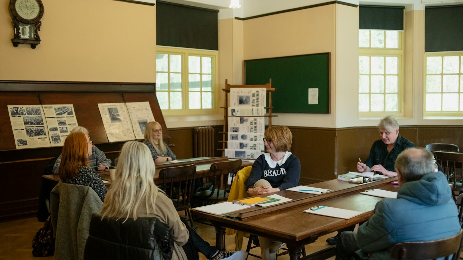 a group of people sitting around a wooden table