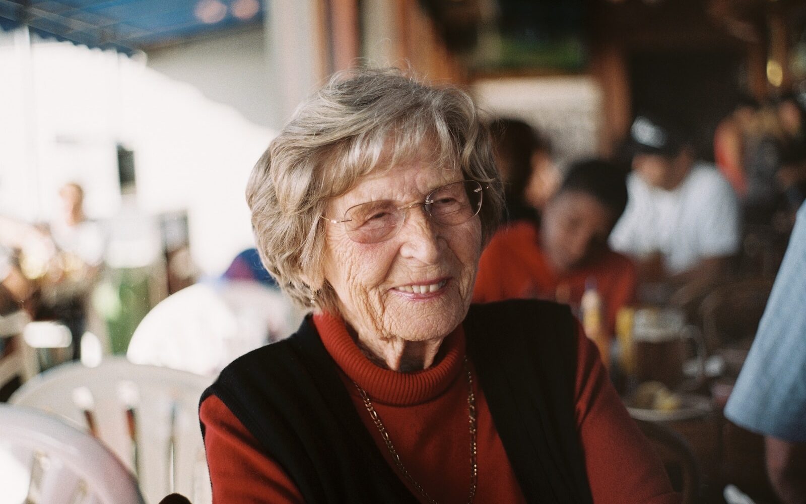 smiling woman in red sweater and black vest