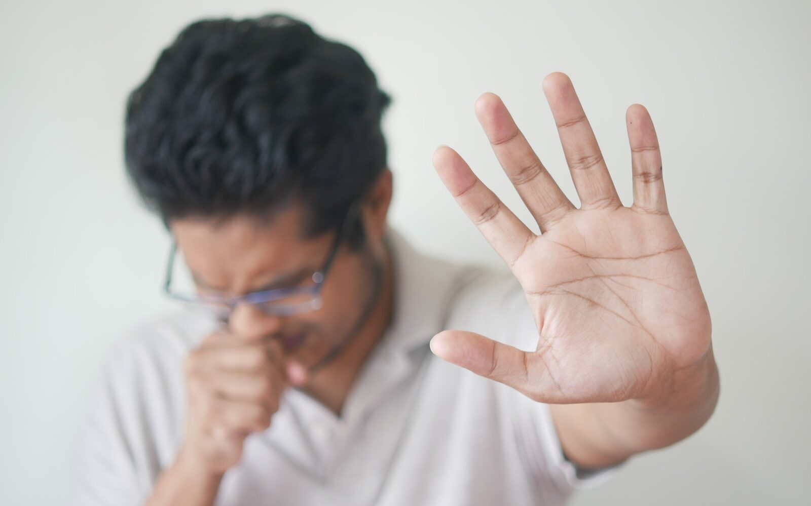 a man holding his hand up in front of his face