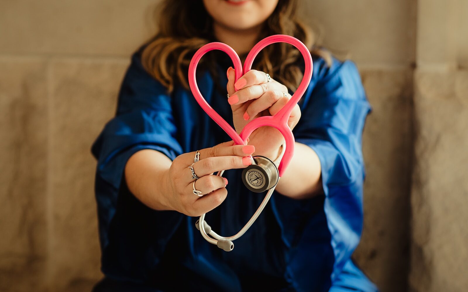 girl in blue jacket holding red and silver ring