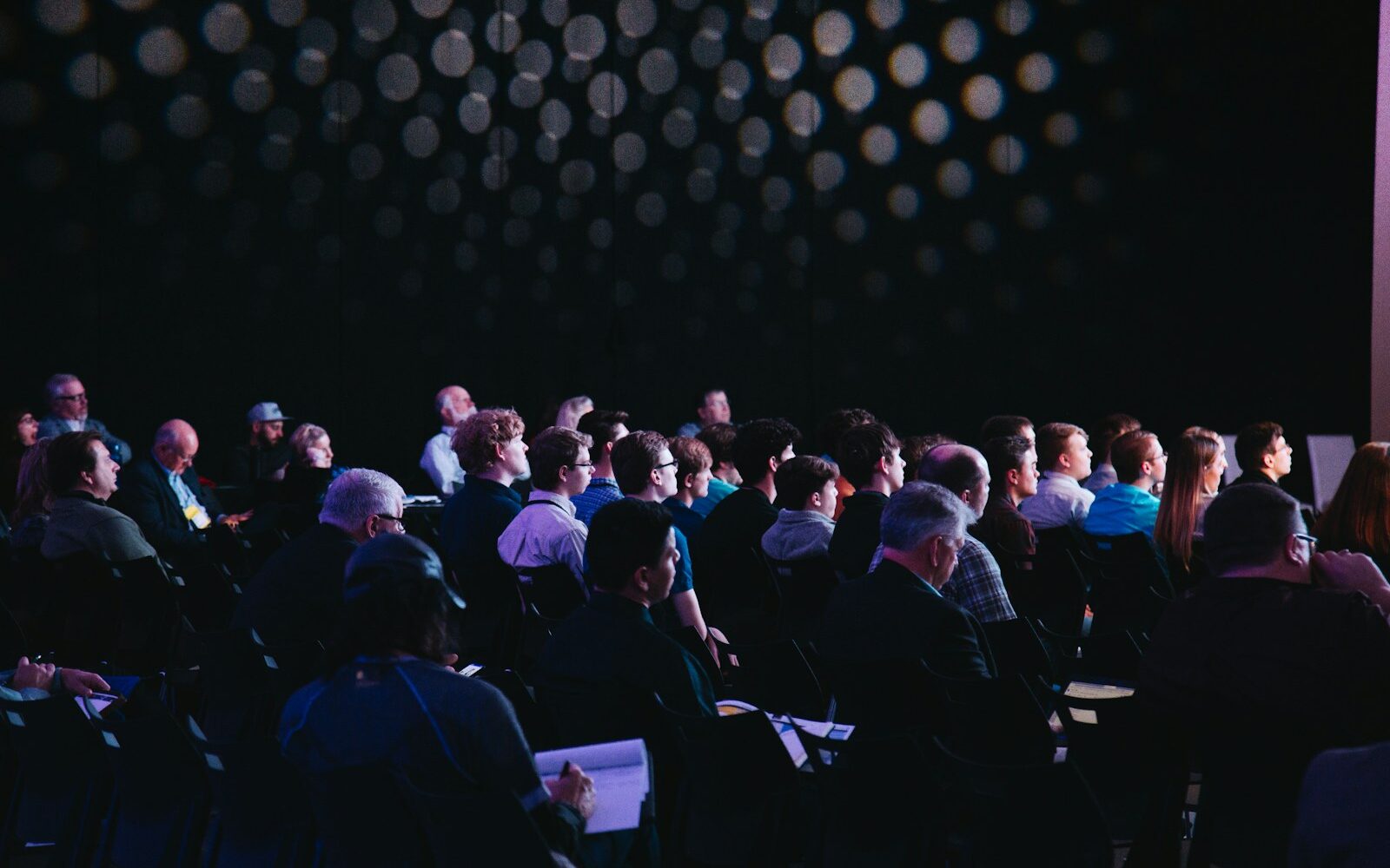 crowd of people sitting on chairs inside room