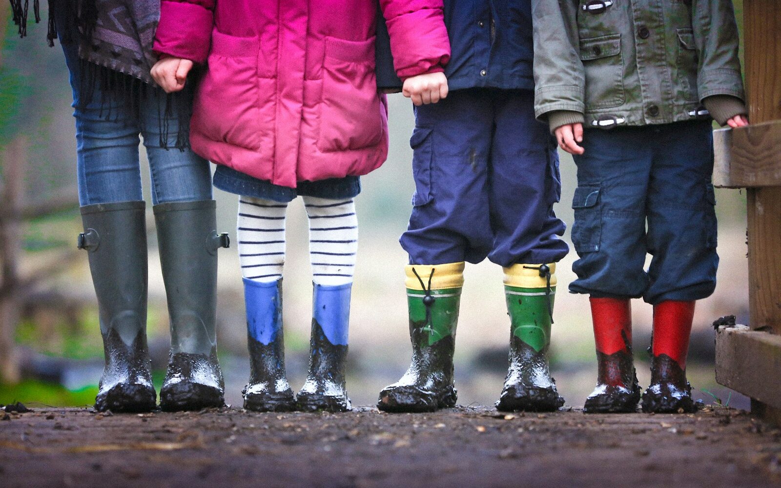 four children standing on dirt during daytime