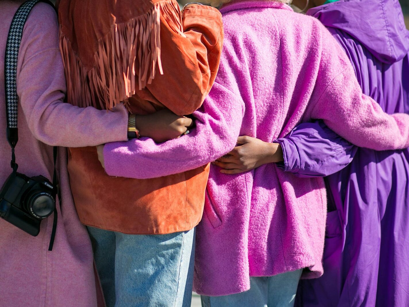 four person holding each others waist at daytime