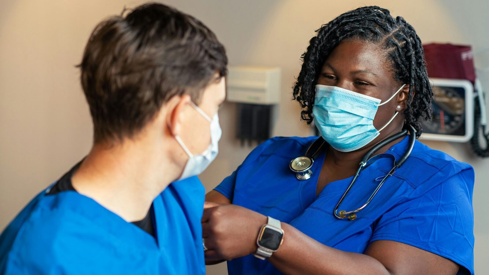 a woman in a blue scrub suit and a man in a blue scrub suit