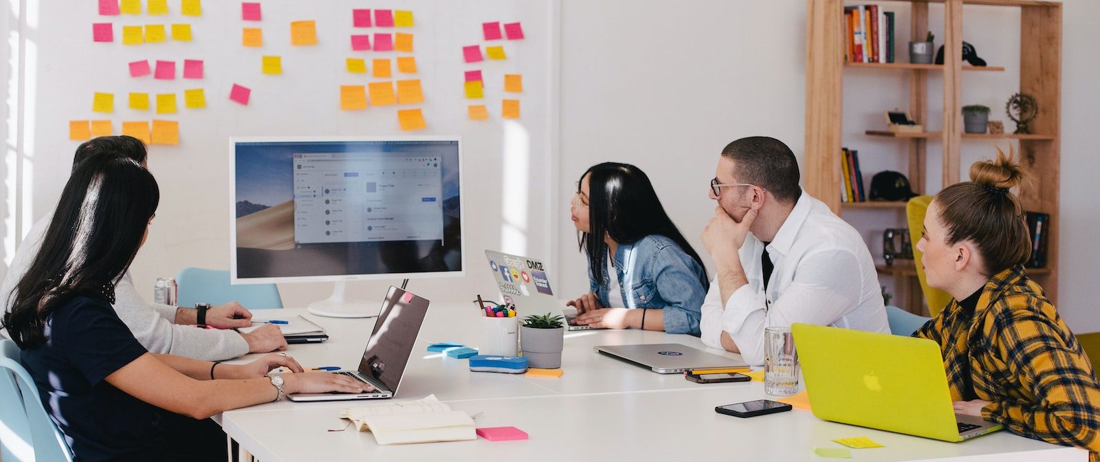 five person by table watching turned on white iMac