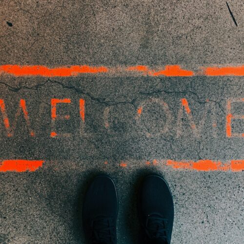 a person standing in front of a welcome sign