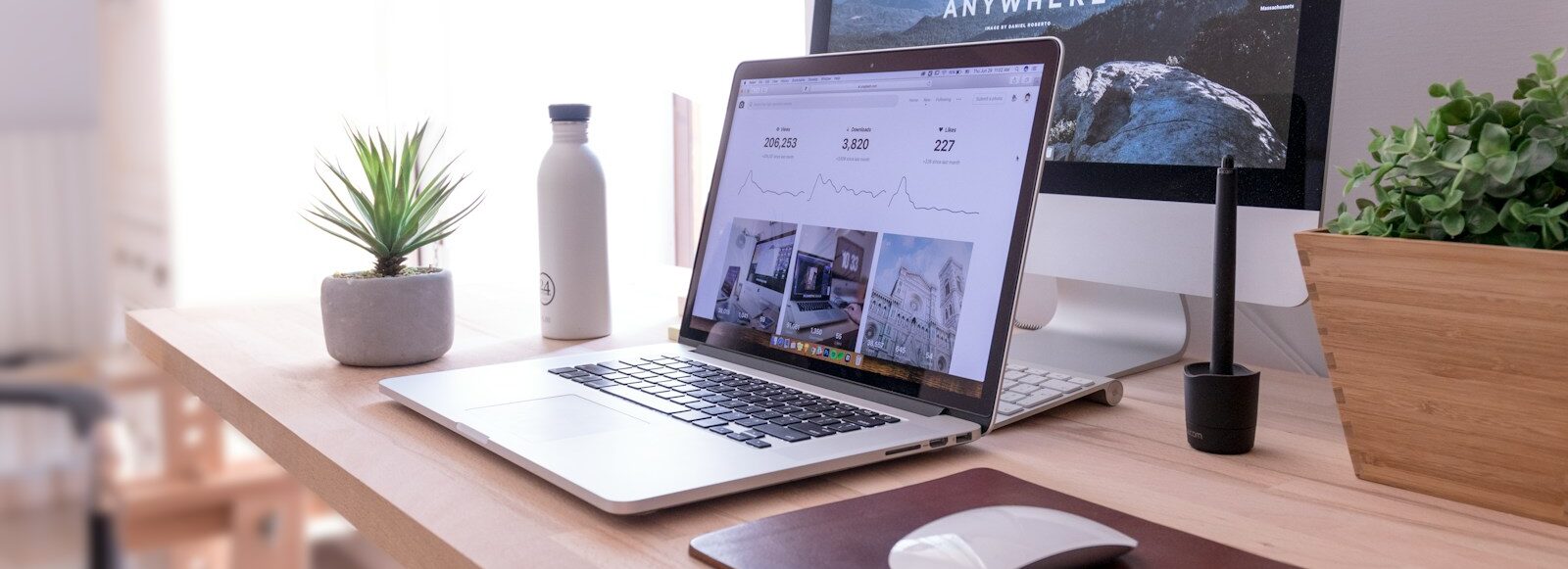 MacBook Pro on table beside white iMac and Magic Mouse