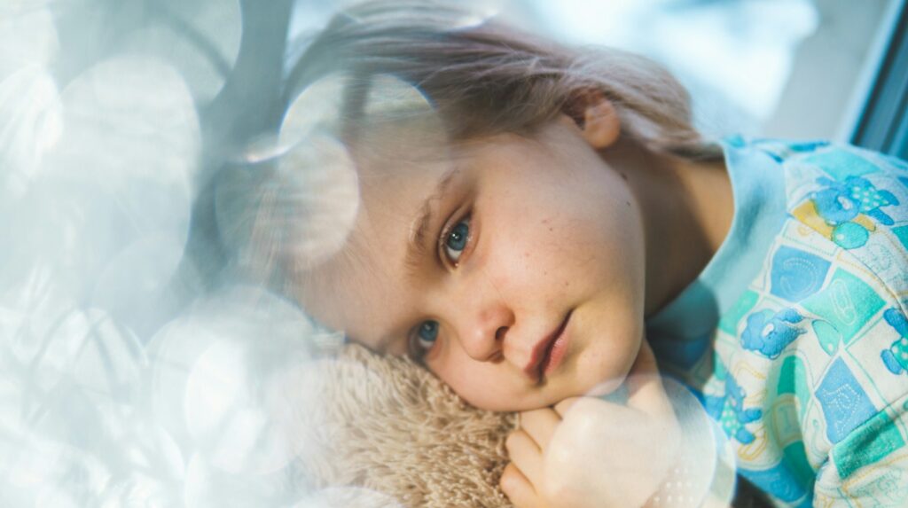 girl in white and blue floral dress lying on white fur textile