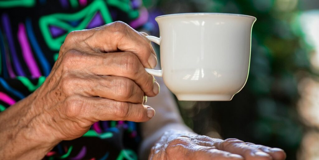 person holding white ceramic teacup