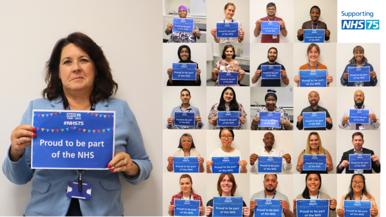 NHC CEO Karen holds up a sign saying Proud to be part of the NHS along with many other past and present NHS workers as part of the NHS's 75th Birthday
