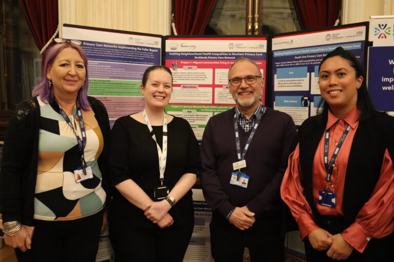 A photo of Rachel Ashworth, Cliff McMahon-Docherty and Khristle Absalud with Public Health colleague Ysabella Hawkings. They stand smiling in from of some of the A1 Healthy Inequalities posters